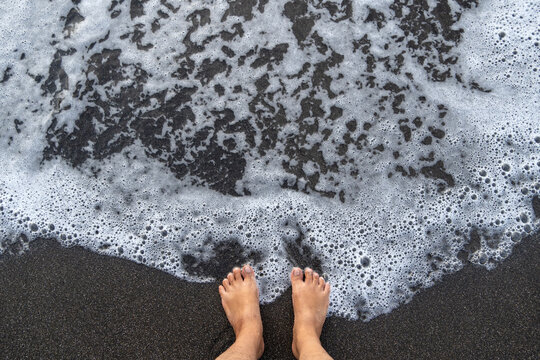 feet on black sand beach