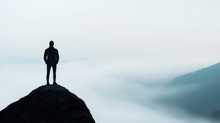 Silhouette of Man on Mountain Peak Overlooking Foggy Valley
