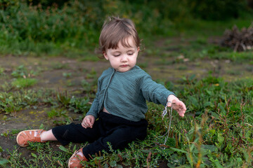 A boy on the shore in the green grass has a picnic