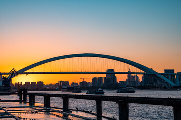Obraz premium Urban arch bridge at dusk, Lupu Bridge scenery in Shanghai, China