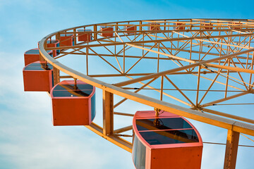 Looking up at the Ferris wheel in the park from a low angle of view
