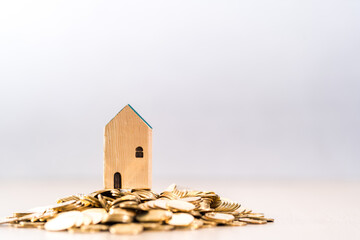 Home model put on the stack gold coin with present to the growing value put on the desk in the office, Loan or save money for buy real estate to family concept.