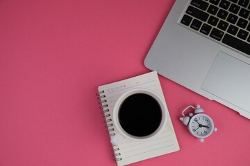 education and back to school concept. alarm clock, scissors, colorful pens, and paper clips over yellow background. top view, flat lay. blank white paper for text space. 