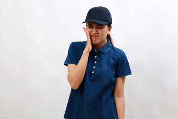 Young hispanic woman courier wearing delivery uniform and cap touching mouth with hand with painful expression because of toothache or dental illness on teeth. dentist