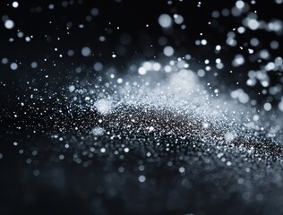 Fototapeta premium Snow falling on a black background, with snowflakes and particles in a depth of field