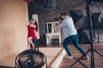 Photo of photographer profesional shooting sexy adorable lady wear red dress indoors studio workplace