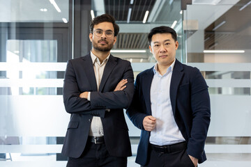 Confident professionals standing in office setting, displaying teamwork and leadership. Business attire enhances their professionalism, conveying success.