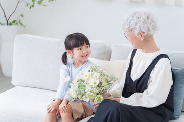 花束のプレゼントを持つおばあちゃんと孫