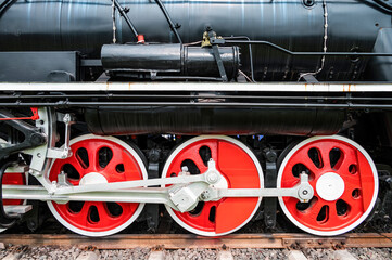 A close-up of the red wheels of the retro Steam locomotive.