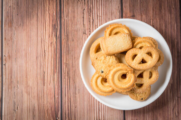 Five whole pretzel, round and rectangular shortbread biscuits with sugar on wood background.