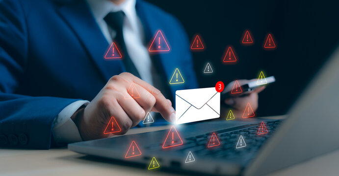 A Businessman working on a laptop open an email with triangle caution warning sign for notification error and maintenance concept, network security, computer virus detected, personal data protection.