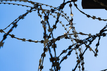 Barbed wire in a prison against a blue sky.