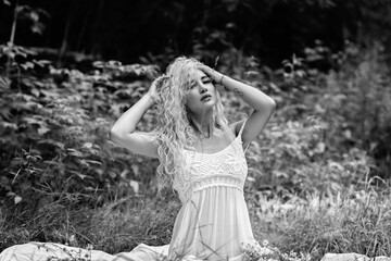 Portrait of a young beautiful blonde girl in nature. Black and white photo.
