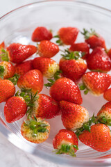 Preparing Strawberries in a Glass Mixing Bowl with Water