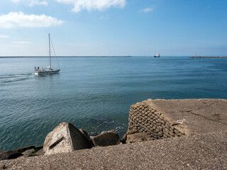 sailing boat and ship at entrance to north sea canal in the netherlands