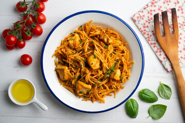 Spanish paella with fideuá and vegetables and chicken. Top view table with decoration.