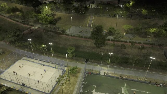 Drone orbits sand volleyball and football courts at night in Parque Elsa Sim&otilde;es in Manaus, Amazonas, Brazil