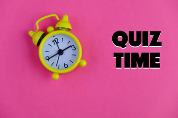 the words Quiz Time beside mini alarm clock on a plain background. the concept of answering quizzes...