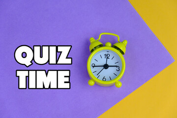 the words Quiz Time beside mini alarm clock on a plain background. the concept of answering quizzes...