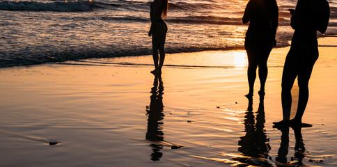Silhouettes of people on the beach at sunset © Raquel