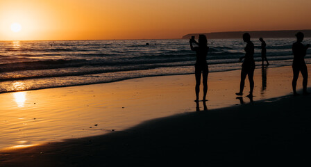 People taking photos on the beach during sunset © Raquel