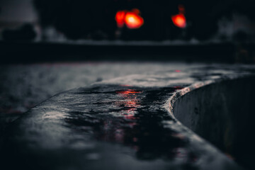 Abstract Reflection of Distant Red Lights on a Curved Wet Surface at Dusk