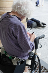 Fototapeta premium Personne âgée assise sur un déambulateur et qui écrit