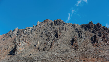 Exposed rocky peaks in high altitude areas under clear blue skies
