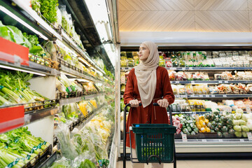 Happy mature Asian woman looking  products at grocery store. Costumer buying food at the market....