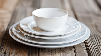 Fototapeta premium White ceramic bowl and plates stacked on a wooden surface, showcasing minimalist tableware and rustic kitchen decor