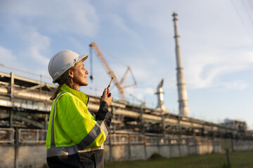 A top-notch female chemical supervisor, making sure the plans are on track by using radio...