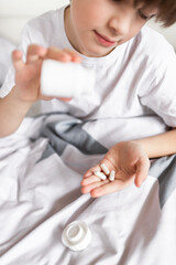 Child eating pills and  supplement vitamins for better immunity. Child taking medicines pills.Medical concept.