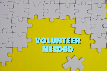 text of volunteer needed on yellow background with missing part of jigsaw puzzle. management and...