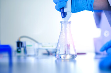 Male scientist working at the laboratory. Cloud up medical hand uses pipette for filling test tube with liquid for test analysis. Scientific Lab for Medicine, Biotechnology Researchers.