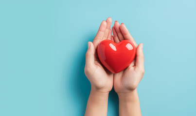 Hands holding a red heart symbolizing love, care, health, and romance against a blue background