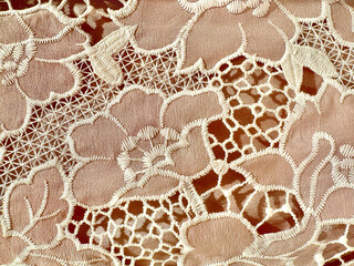 Close up of pink peach nylon fabric sewn in flower pattern with some decorative pleated nets and...