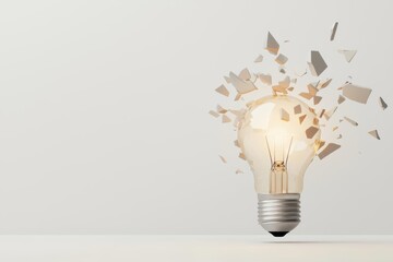 A light bulb shattering into pieces against a plain background.
