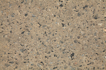 Light-gray concrete surface, background. Texture of concrete slab or supporting wall with gravel or crushed stone inclusions. Grey but yellowed concrete backdrop. Two-component concrete pattern