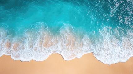Obraz premium Top-down shot of a crystal-clear blue sea with sunlight sparkling on the waves and a golden sandy beach