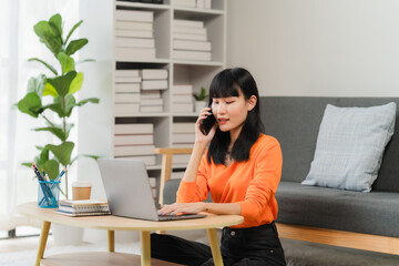 Modern Work-Life Balance: A young woman seamlessly blends work and personal life, taking a phone call while working on her laptop at home, surrounded by greenery and comfortable decor.