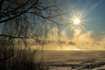 Winter forest landscape. Morning winter mist on the river - winter forest landscape in sunrise