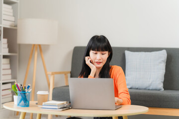 Focused on the Task: A young woman works diligently on her laptop, engrossed in her work. The comfortable setting and relaxed posture suggest a sense of ease and focus.  