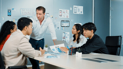 Professional smart businessman present Ux and Ui design to marketing team. Project manager sharing idea about business plan. Diverse business team working together to brain storm idea. Manipulator.