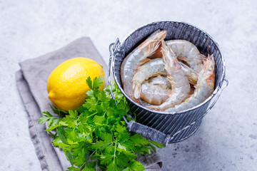 Fresh raw shrimps, accompanied by sprigs of fresh parsley and juicy lemon