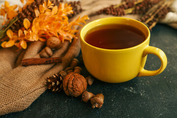 Cozy autumn scene with tea, pastry, yellow roses, and warm knitted sweaters