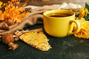 Cozy autumn scene with tea, pastry, yellow roses, and warm knitted sweaters