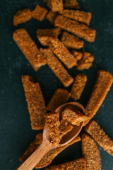 Wooden bowl filled with crispy rye croutons placed on a burlap cloth, creating a rustic snack presentation