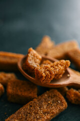 Wooden bowl filled with crispy rye croutons placed on a burlap cloth, creating a rustic snack presentation