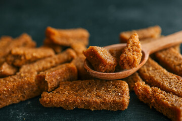 Wooden bowl filled with crispy rye croutons placed on a burlap cloth, creating a rustic snack presentation