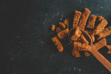 Wooden bowl filled with crispy rye croutons placed on a burlap cloth, creating a rustic snack...